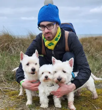 Kay De Greef A man hugging his three dogs which are called Kenzo, Kwinto and Buddy.
